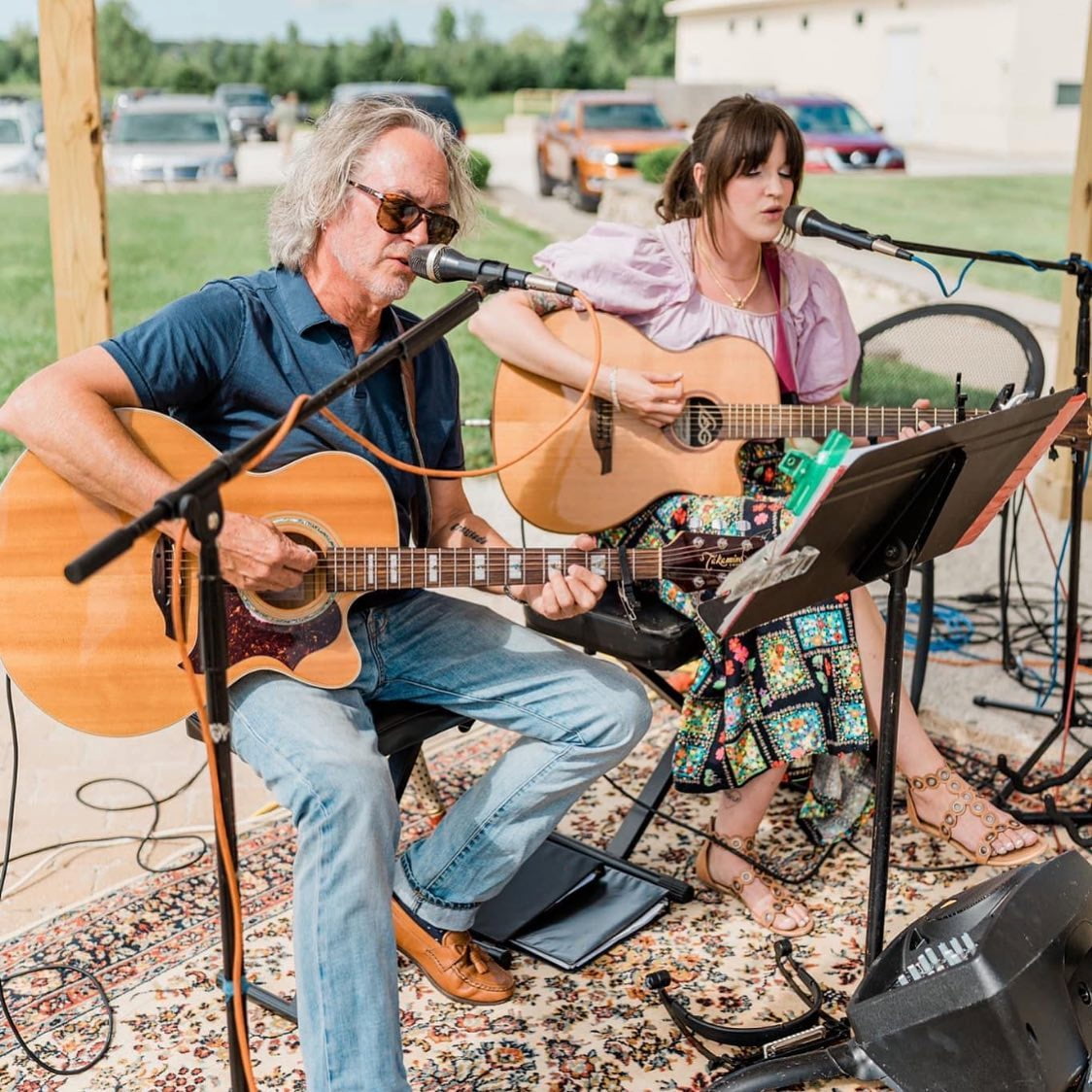 John and Cass performing at an outdoor venue together